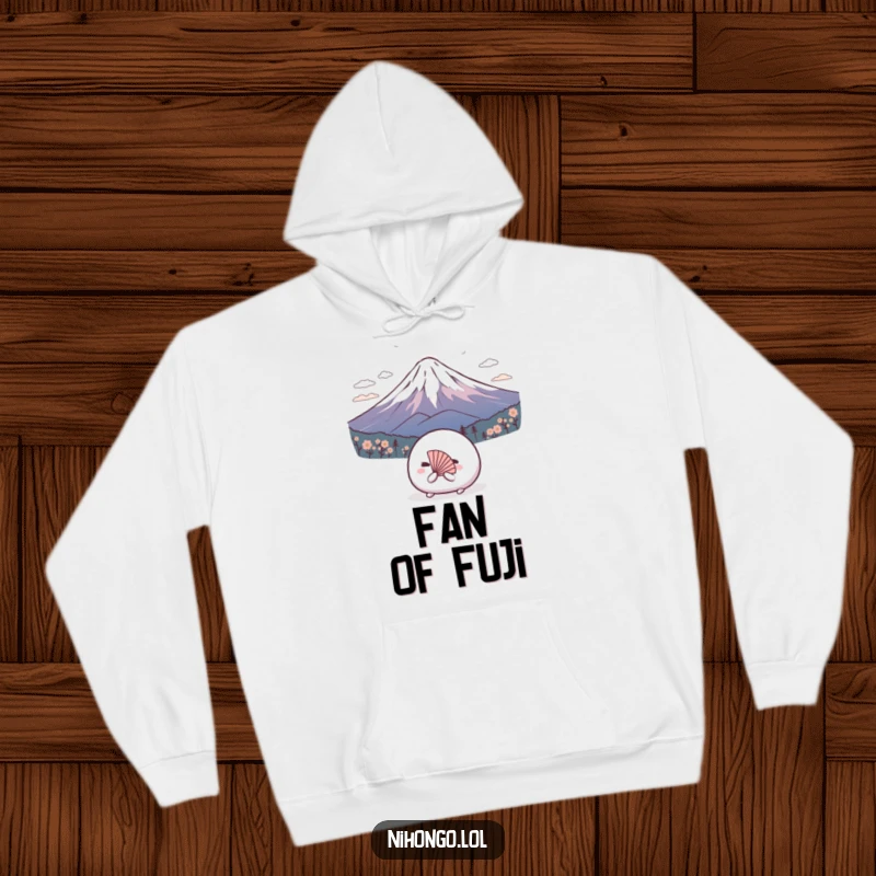 Funny hoodie design of a shy mochi ball wearing a tiny fan, bowing deeply to Mount Fuji, comfortable and cute.